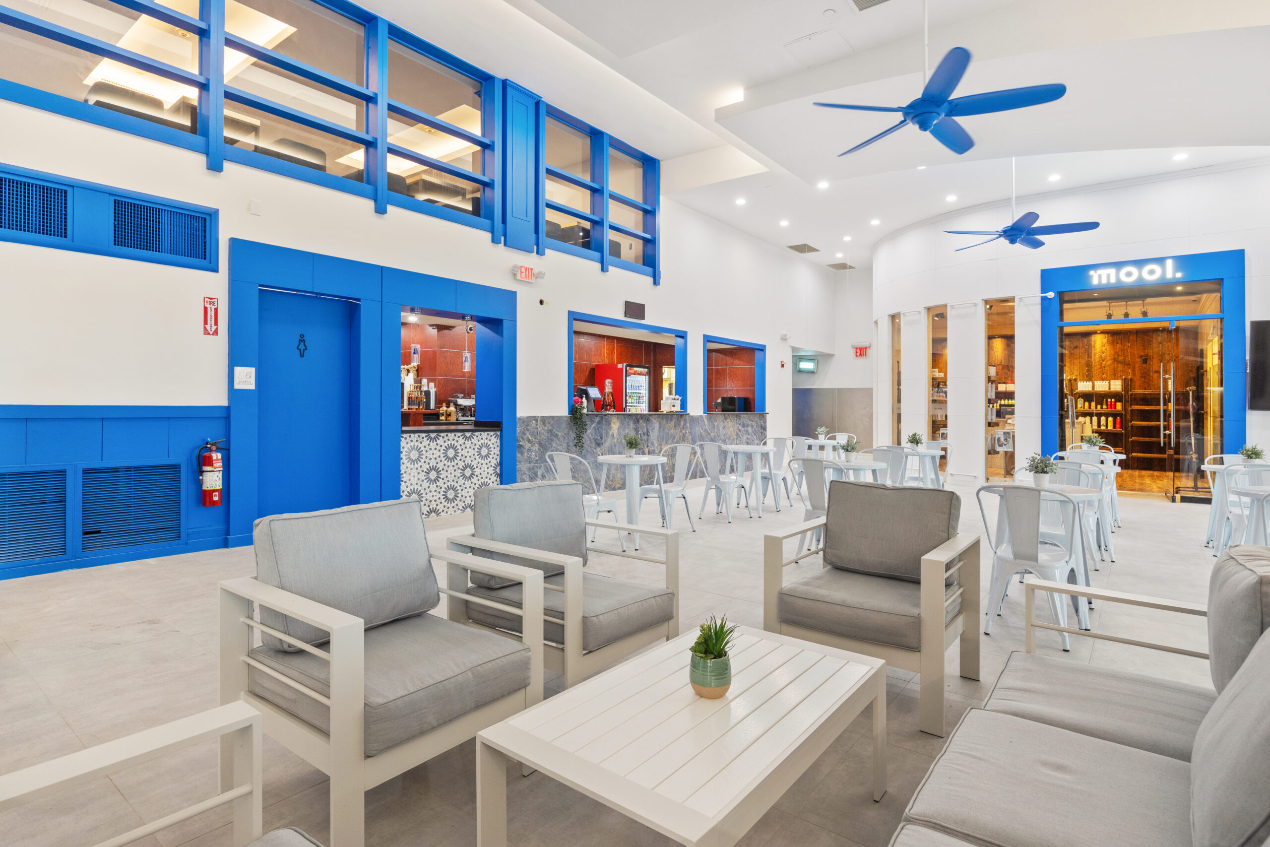 View of first floor kitchen and entrance to Mool, with views of seating and eating area, as well as female restroom.