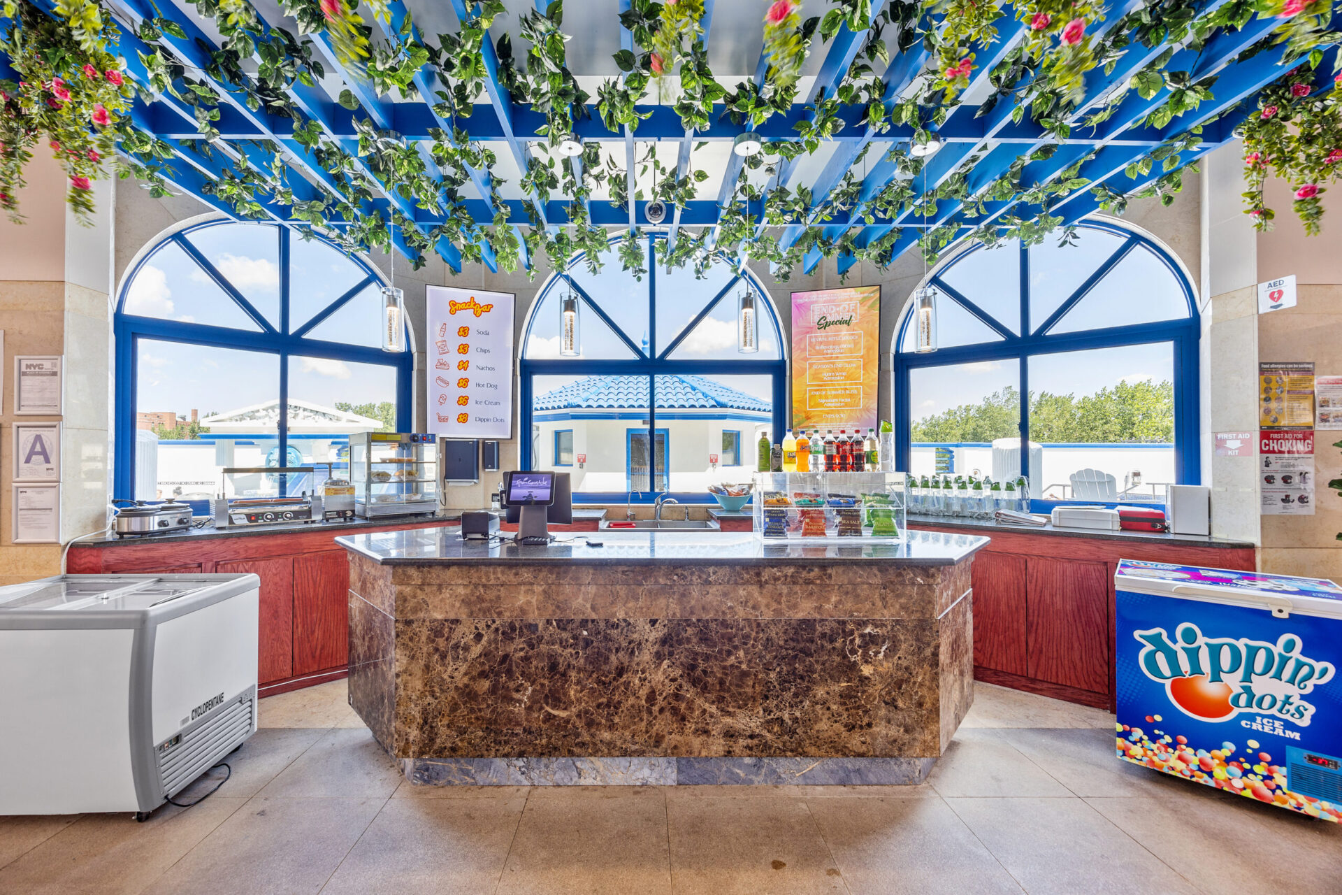 View of the snack bar, showcasing hotdogs, chips, soda and ice cream on the counter.