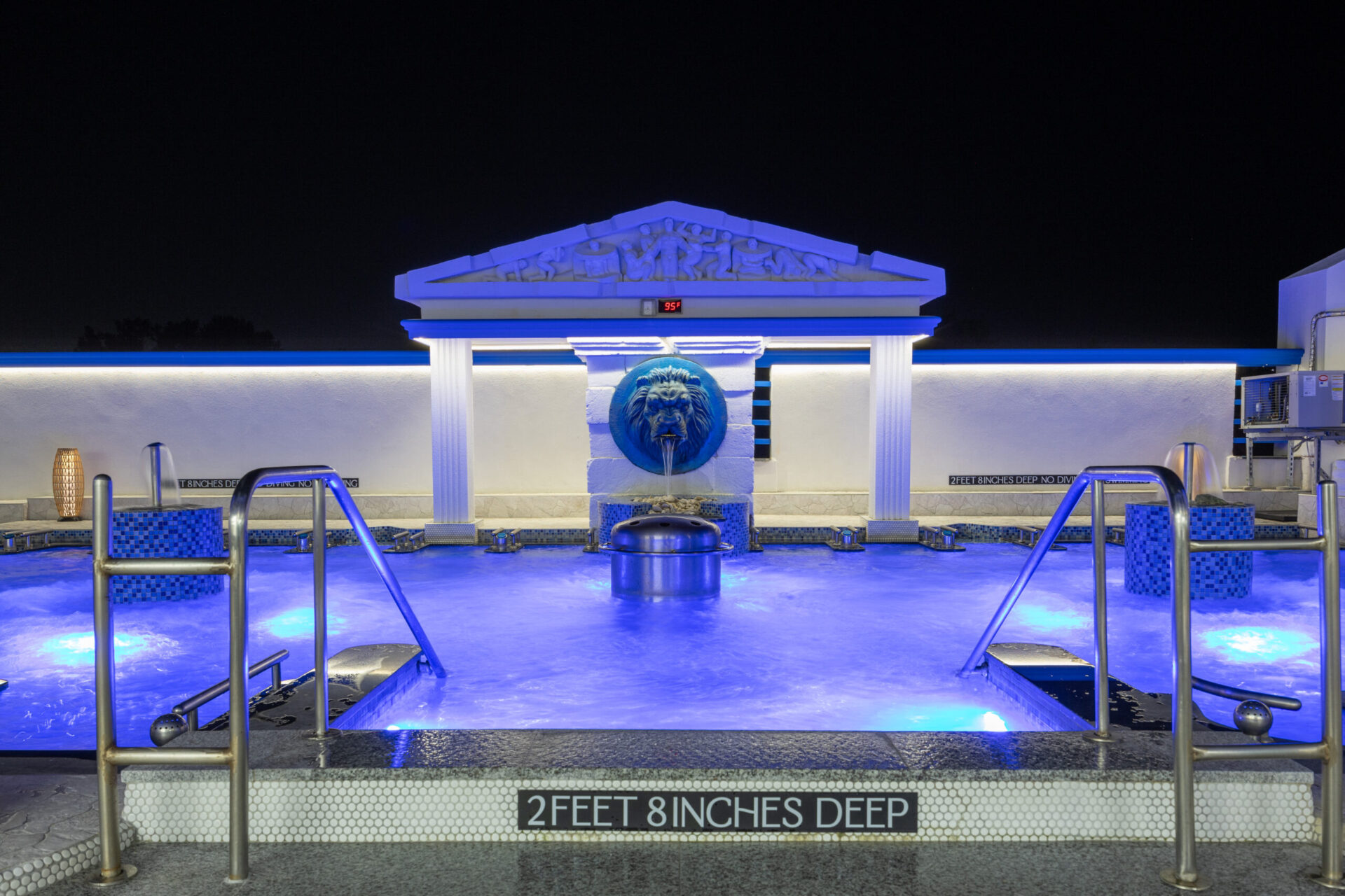 nighttime view of the center of the seated medi pool, focusing on the lion water fountain.