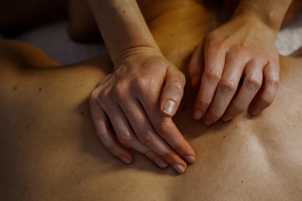 Therapist applying targeted pressuring to a guest's back, known as Shiatsu.