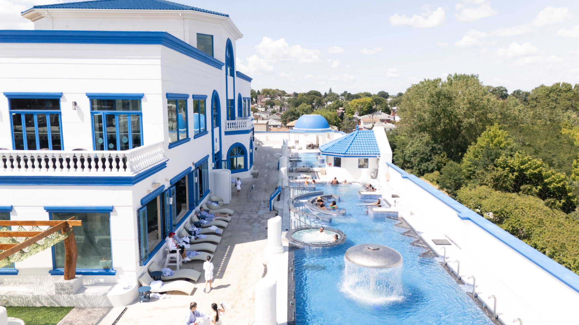 A elevated view of spa castle's outdoor pools. Focusing on the standing medi pool, featuring many guests enjoying the pool.